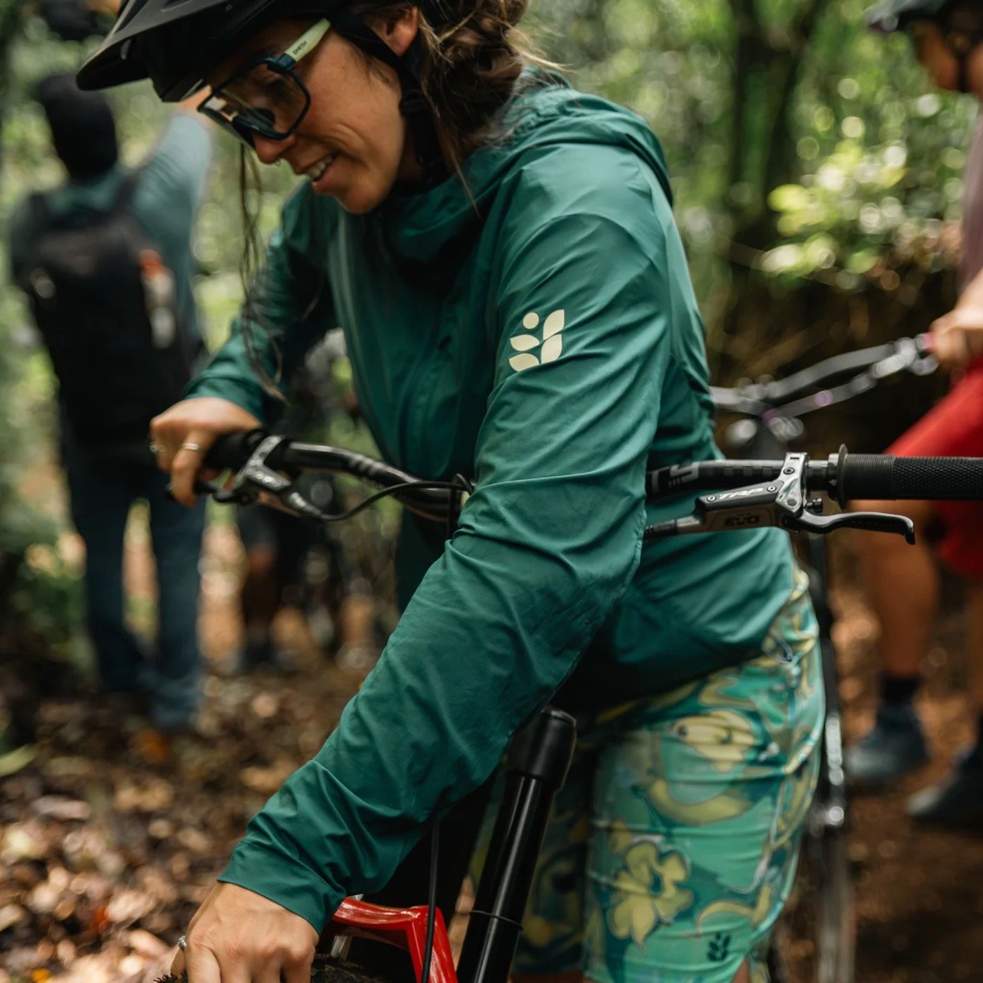 a woman wearing the green color of the rustler windbreaker.