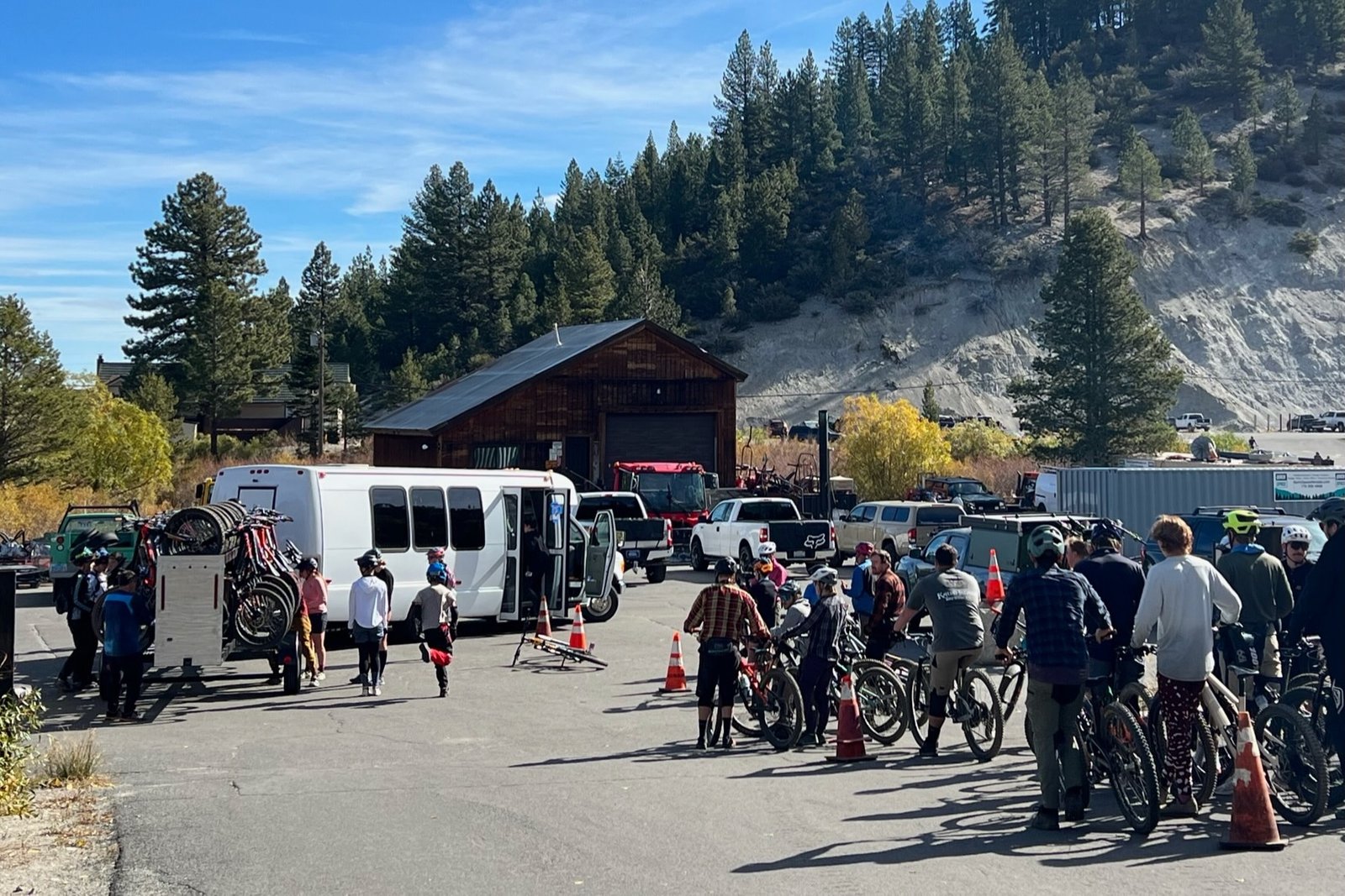 riders lined up and loading a shuttle with mountain bikes.