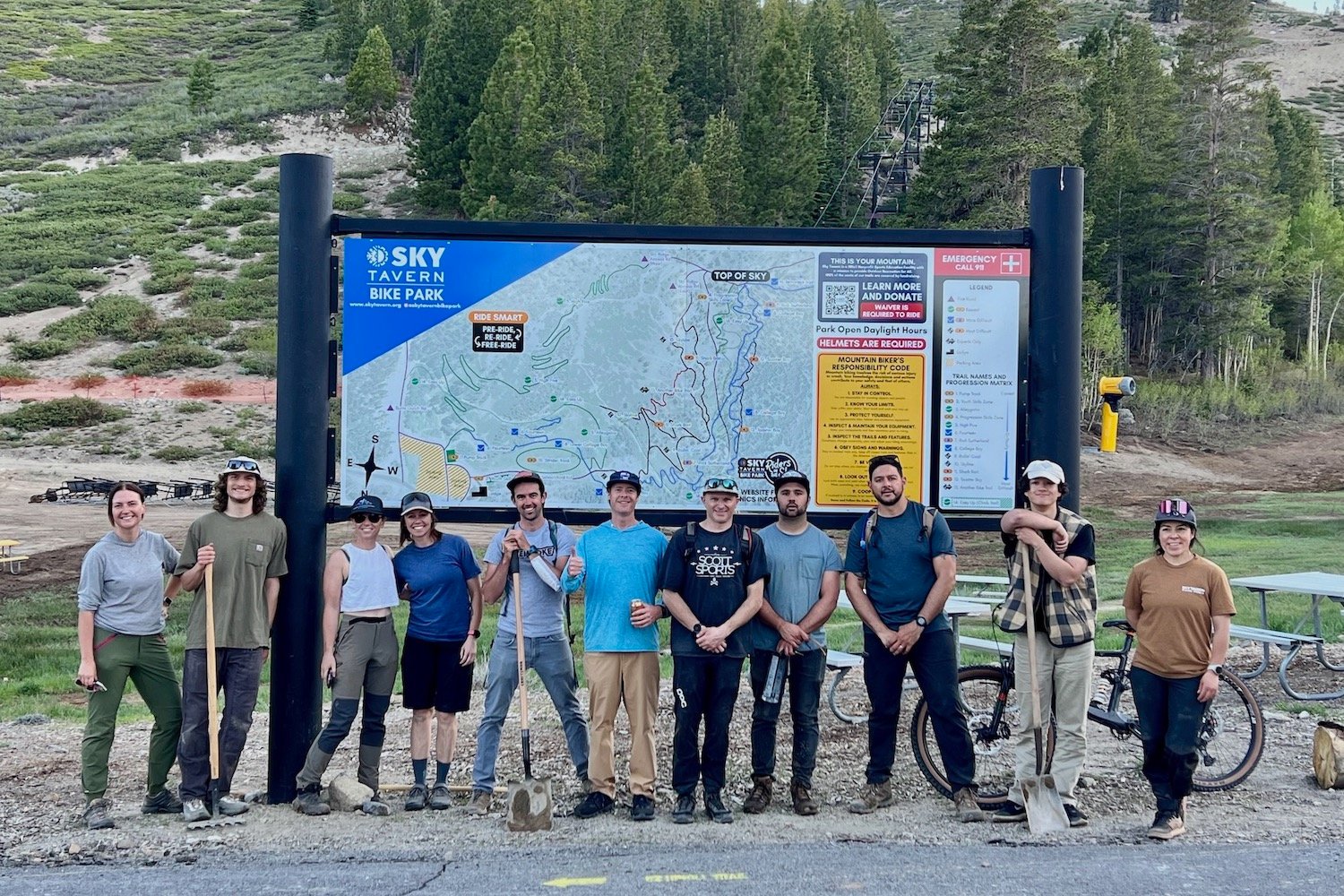 a group of volunteers posing by the Sky Tavern trial map after doing trail work