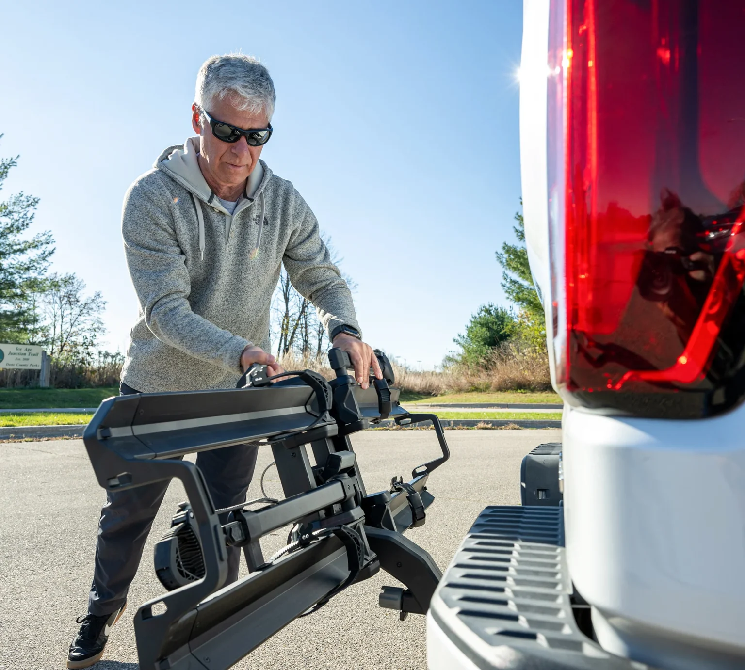 man folding up saris cycle-on hitch bike rack.