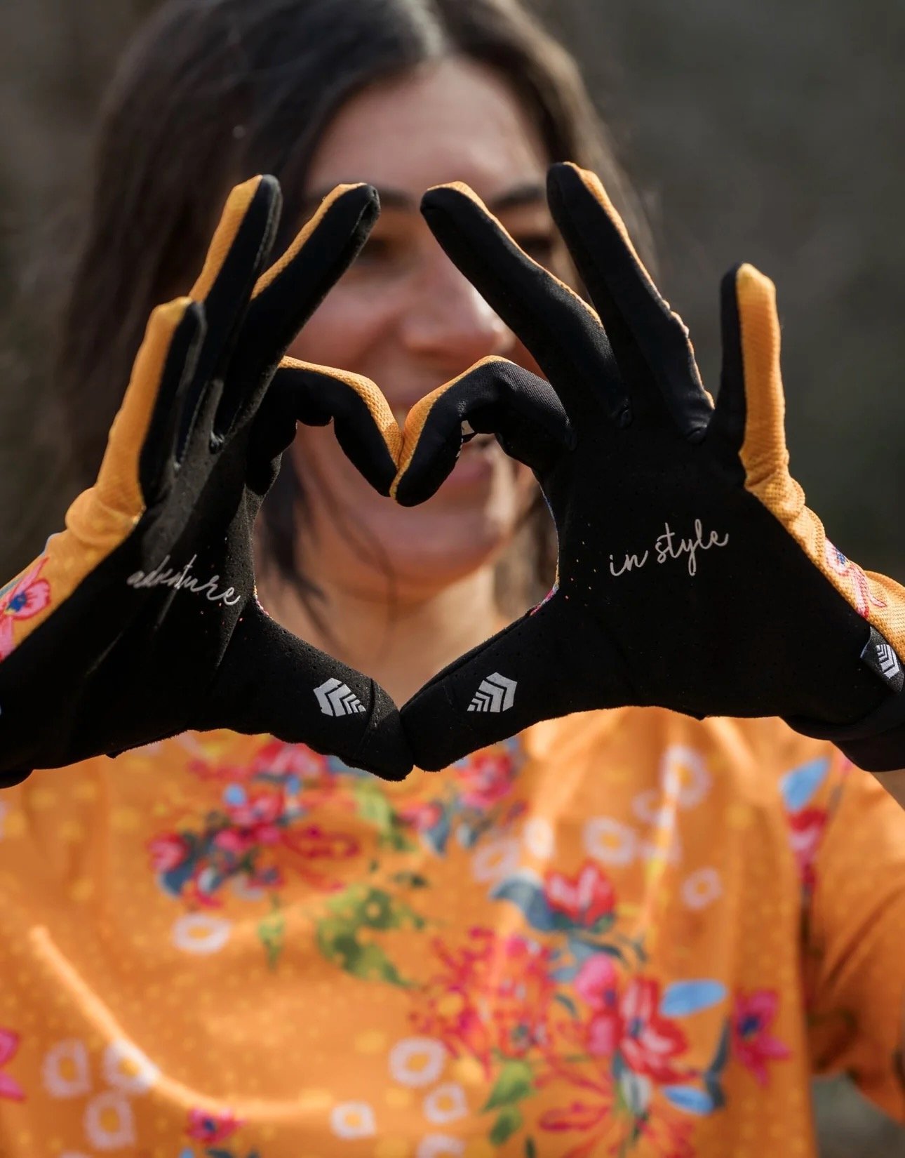 a female rider making a heart shape with Shredly gloves on