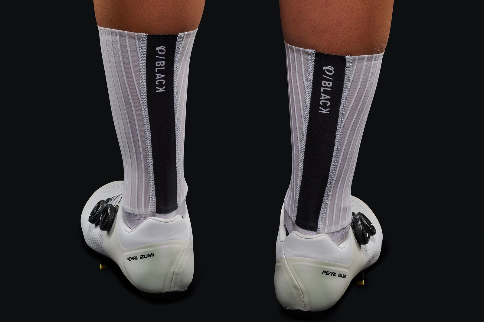 studio image of a person wearing the Pi Black Aero Socks.