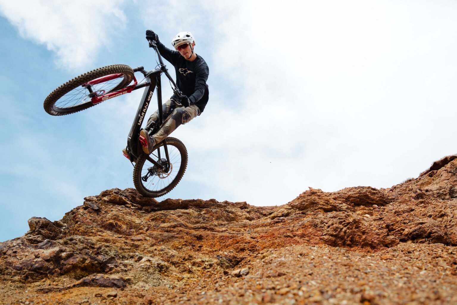 a rider jumping off a rock on the Lee Cougan Flö eMTB.