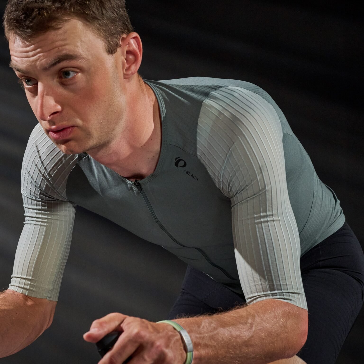 studio image of a man wearing the Pi Black jersey, in the riding position.