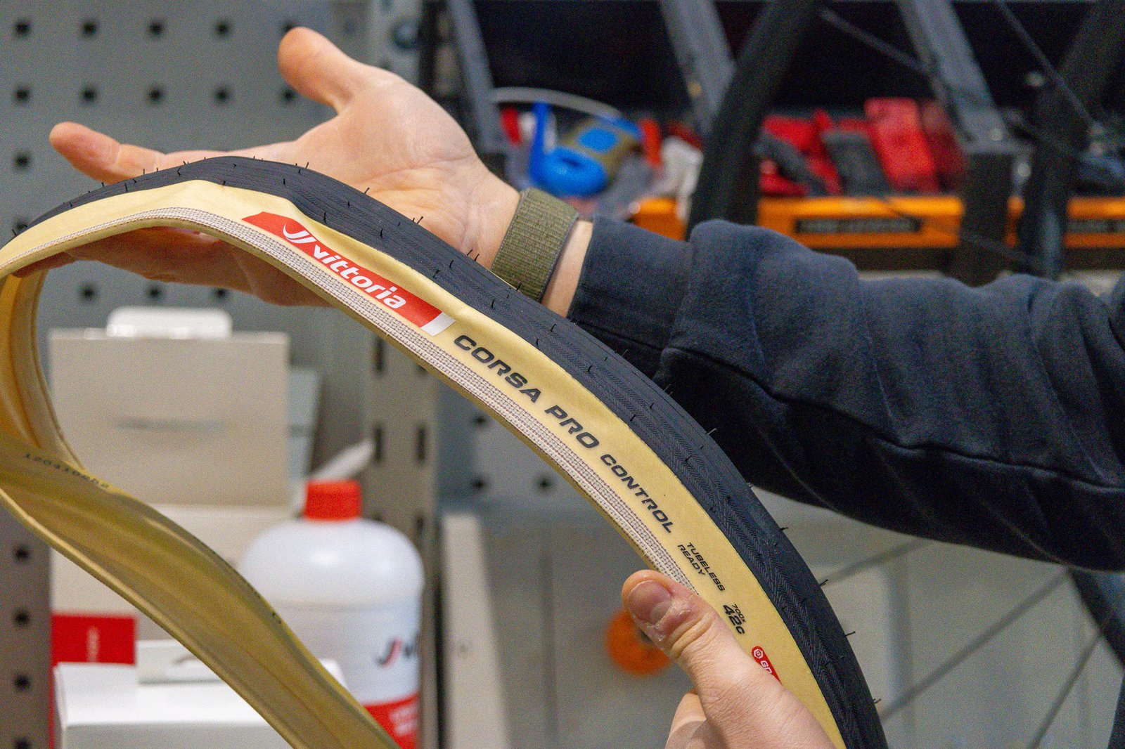 closeup of hands holding unmounted new vittoria corsa pro control 38 and 42 mm tires.